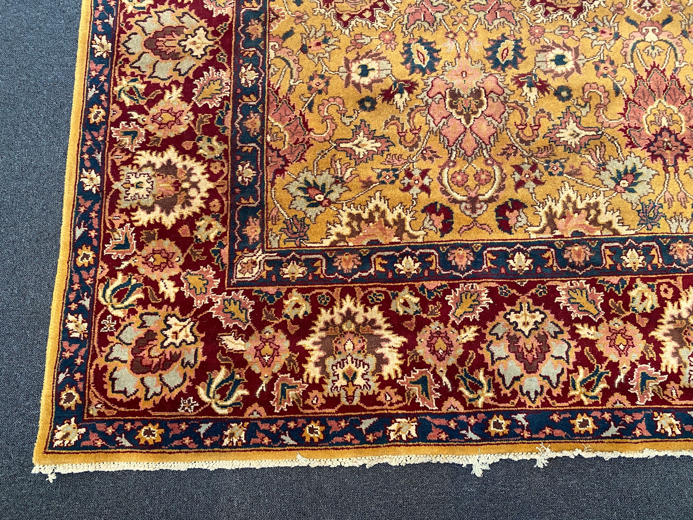 An Agra gold ground carpet with dense palmette field and wide conforming border 360 x 280 cms